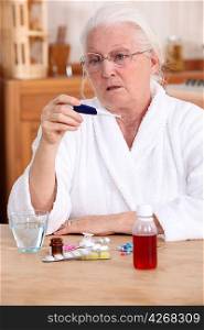 Elderly woman taking her temperature