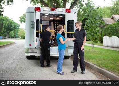 Elderly woman thanking ambulance staff for help