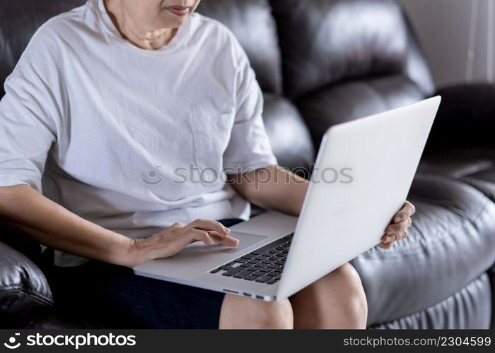 Elderly woman using her computer in home and using laptop