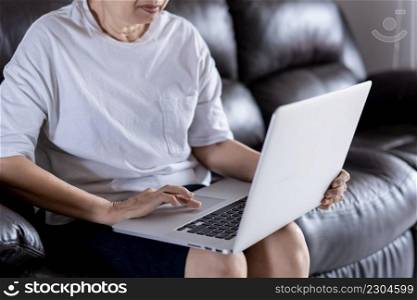 Elderly woman using her computer in home and using laptop