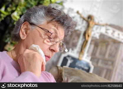 elderly woman with a crucifix in the backgroud
