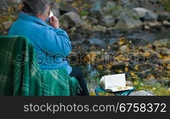 elderly woman with a cup of coffee at Autumn park, Side View