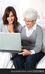 Elderly woman with grandaughter with laptop computer