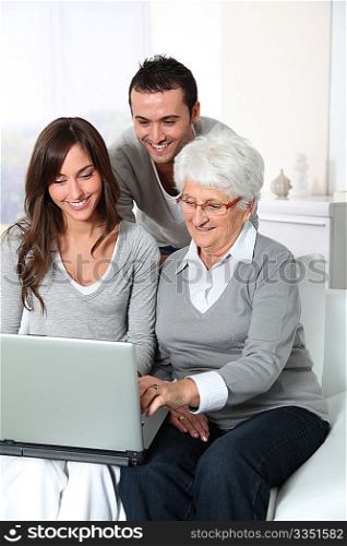 Elderly woman with grandchildren looking at laptop computer