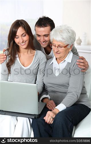 Elderly woman with grandchildren looking at laptop computer