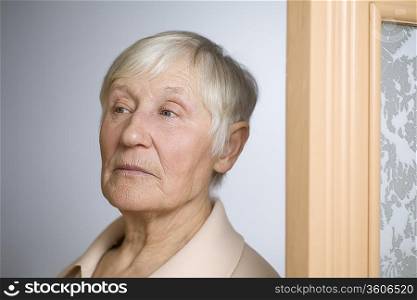 Elderly woman with short grey hair in doorway