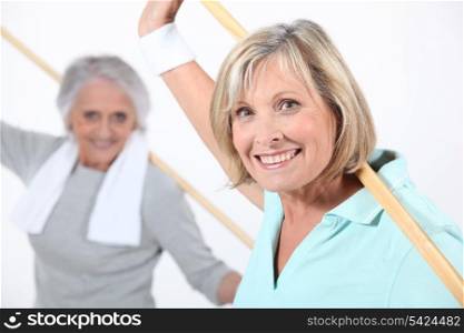 Elderly women stretching with wooden pole