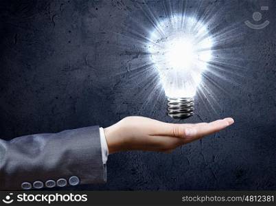 Electric bulb. Close up of businesswoman hand holding bulb in palm