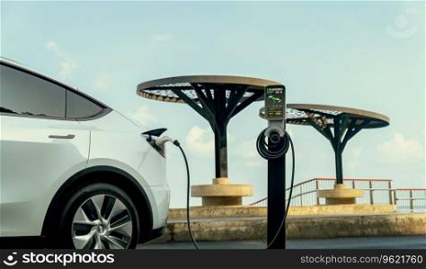 Electric car recharging battery at outdoor EV charging station for road trip or car traveling by the seascape, alternative and sustainable energy technology for eco-friendly car. Perpetual. Electric car recharging battery at outdoor EV charging station. Perpetual