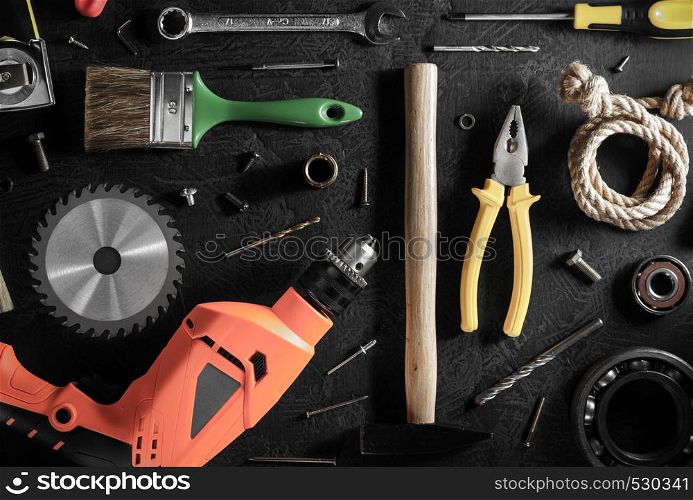 electric drill and tools on black background