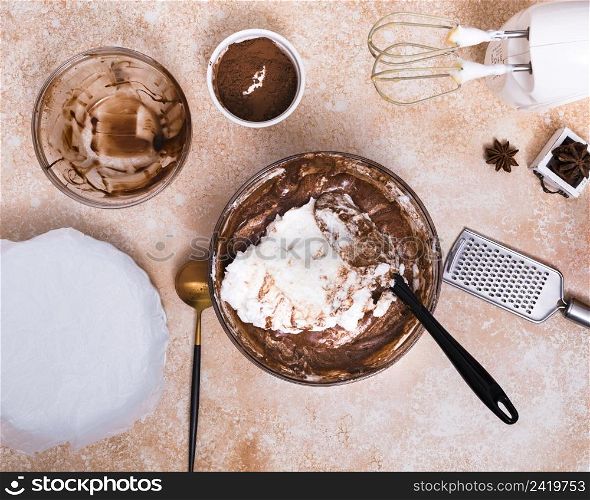 electric food mixer hand grater star anise cocoa powder cake dough brown textured background