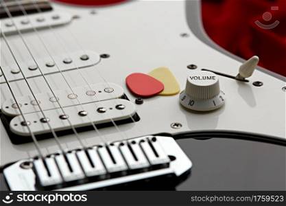 Electric guitar closeup, red background, nobody. String musical instrument, electro sound, electronic music, equipment for stage concert. Electric guitar closeup, red background, nobody