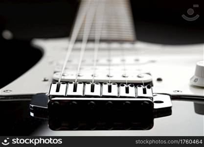 Electric guitar, focus selection on strings, black top on background, nobody. Musical instrument, electro sound, electronic music, equipment for stage concert. Electric guitar, focus selection on strings