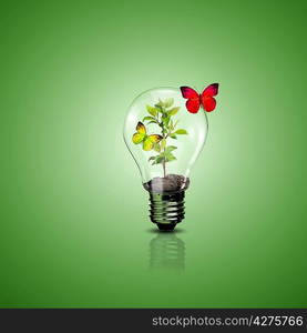 Electric light bulb and a plant inside it as symbol of green energy