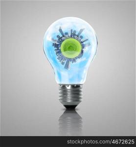 Electric light bulb and our planet inside it as symbol of green energy