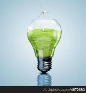 Electric light bulb and wind meels inside it as symbol of green energy