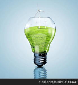 Electric light bulb and windmills inside it as symbol of green energy