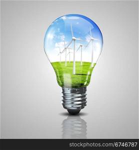 Electric light bulb and windmills inside it as symbol of green energy