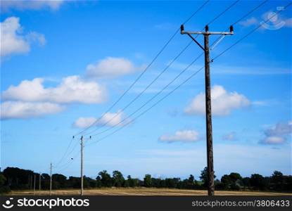 Electric lines in a rural landscape with blue sky