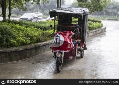 Electric pedicab taxi in the rain