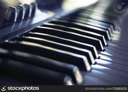 Electric piano keyboard in blur. Piano keyboard with day light reflections.