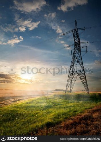 Electric pole and autumn field at sunrise