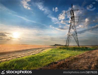 Electric pole in the autumn field at sunrise