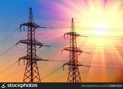 electric power transmission towers at sunset