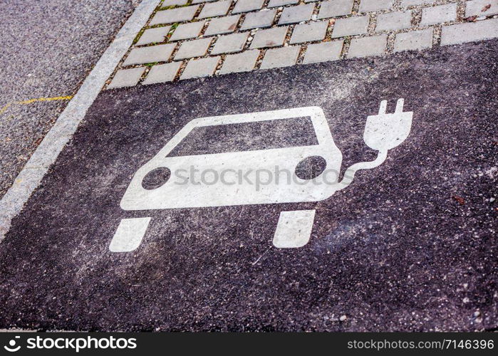 Electric vehicle charging station sign on asphalt parking lot. Eco transport concept