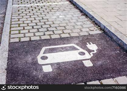 Electric vehicle charging station sign on asphalt parking lot. Eco transport concept