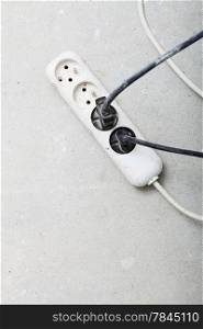 electrical cords connected to a power strip or extension block in construction site