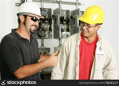 Electrical foreman giving a worker the thumbs-up. Models are actual electricians.