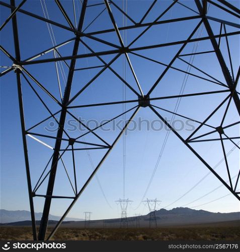 Electrical power lines in barren desert landscape.