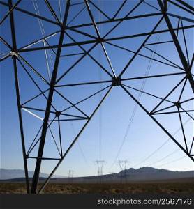 Electrical power lines in barren desert landscape.