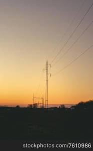 Electrical pylons at dawn in a beautiful sunset with a clear sky