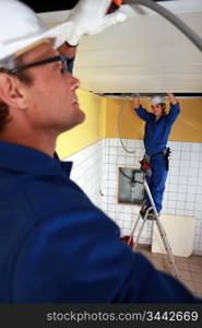 Electrical team wiring a tiled room