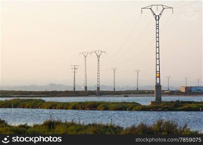 electrical towers over a marshy area