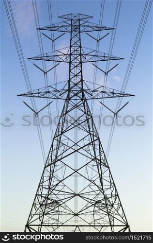 Electrical transmission tower with blue sky background.