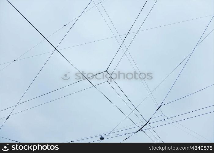 Electrical wires and a lantern on the background of blue sky