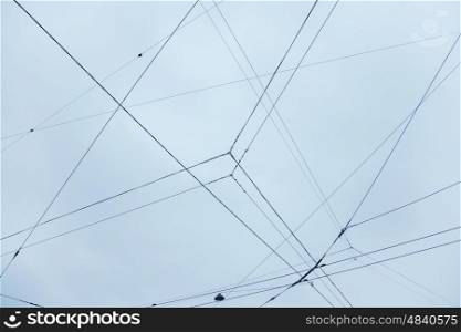 Electrical wires and a lantern on the background of blue sky