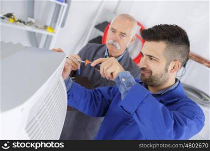 electrician and manager repairman fixing air conditioning