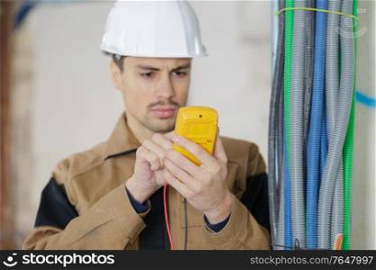 electrician checking voltage with digital multimeter