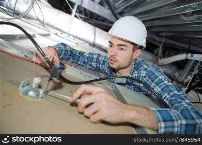 electrician fitting a led light to the ceiling