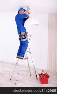 Electrician hanging a ceiling light