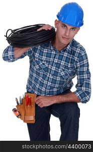 Electrician holding coil of cable over shoulder
