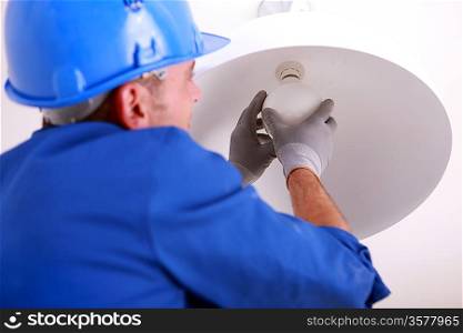 Electrician installing new light bulb