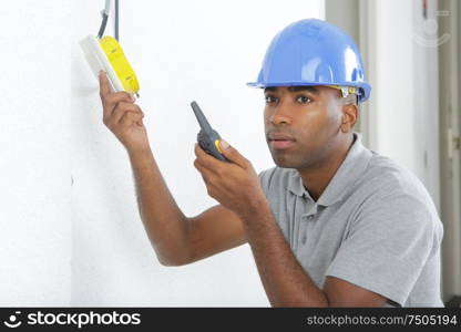 electrician installs paired socket on the wall
