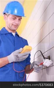 electrician is checking an outlet with an ammeter