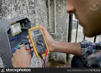 Electrician using a voltmeter device
