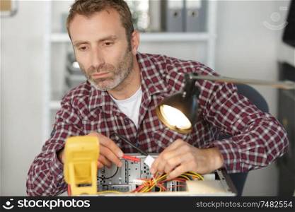 electrician using multimeter to test computer